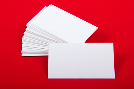 Blank business cards at red textured background. Template for ID. Top view.の写真素材