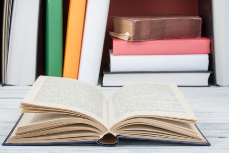 Open book, hardback colorful books on wooden table. Back to school. Copy space for text. Education business concept.の写真素材