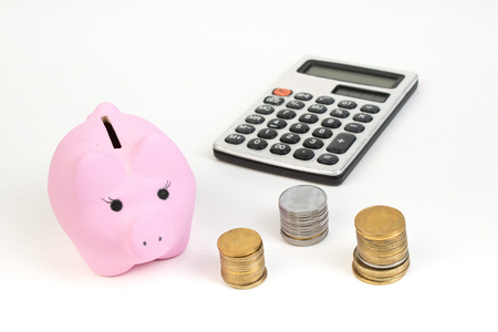 The of coins, calculator, Pink piggy bank on white isolated background.の写真素材