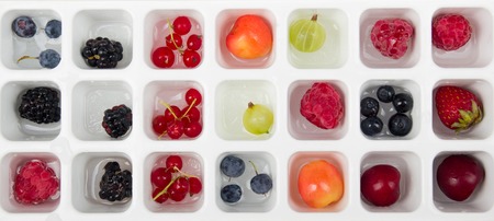 Berries frozen in ice cubes with mint on plate.の写真素材