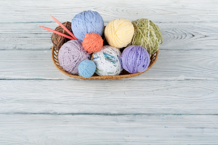 Colored yarn on a white background. Skeins of wool yarn for knitting. Balls of wool with spokes of different colours for handmade knitting on a wooden background with copy space for ad.の写真素材