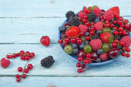 Various summer Fresh berries in a bowl on rustic wooden table. Antioxidants, detox diet, organic fruits.の写真素材