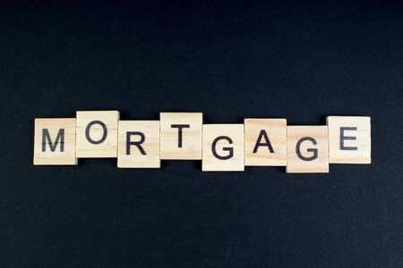mortgage- word composed fromwooden blocks letters on black background, copy space for ad text.の写真素材