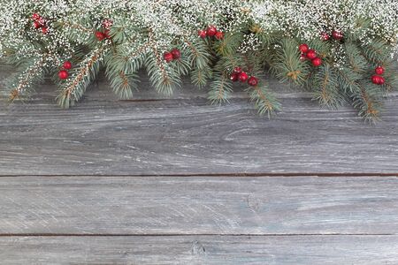 Christmas composition of fir branches and berries of viburnum on a wooden background . Top view with copy space.の写真素材