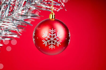 Christmas composition of fir branches and Christmas balls of viburnum on a red backgroundの写真素材