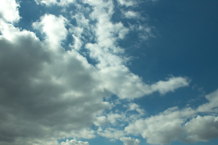 Blue, clear sky with clouds and sun.の写真素材