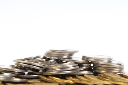 Gold towers made out of gold and silvery coins, stack isolated on white.