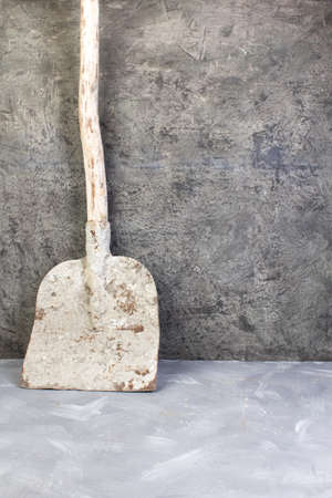 old, dirty shovel on the gray concrete background. Copy space. Top view.の写真素材