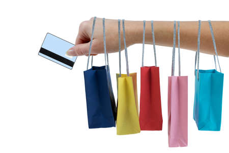 Crop female hand holding colorful paper bags and paying with a debit or credit card isolated on white background.の写真素材
