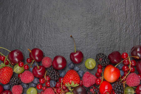 Various summer Fresh berries in a bowl on rustic wooden table. Antioxidants, detox diet, organic fruits. Top viewの写真素材