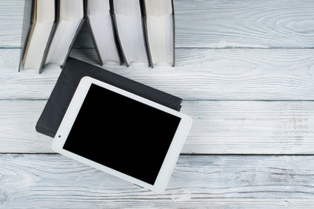Open books on wooden table, black board background. Back to school. Education business concept.