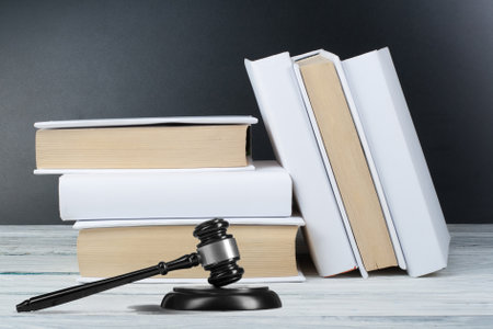 Law concept - Open law book with a wooden judges gavel on table in a courtroom or law enforcement office isolated on white background. Copy space for text.の写真素材