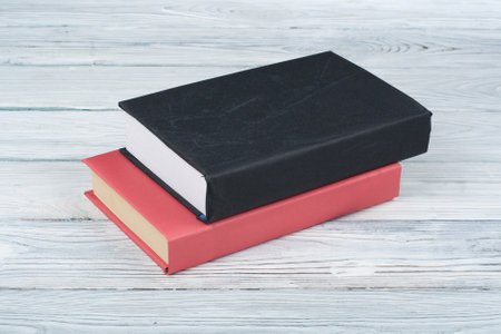 Hardback books on wooden table, white background. Back to school. Copy space for text. Education business concept.の写真素材