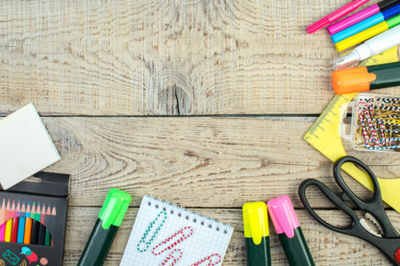 back to school. Scissors, pencils, paper clips, notepad, markers, ruler. School supplies on a wooden table. top view with copy spaceの写真素材
