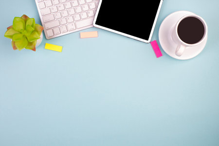 Tablet, calculator, phone, pen and a cup of coffee, lot of things on a blue background. top view with copy spaceの写真素材