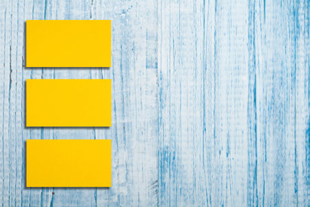 Mockup of horizontal gold business cards stacks arranged in rows at blue wooden background.の写真素材