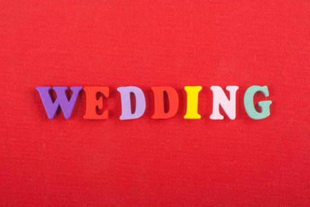 WEDDING word on red background composed from colorful abc alphabet block wooden letters, copy space for ad text. Learning english concept.の写真素材