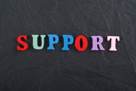 SUPPORT word on black board background composed from colorful abc alphabet block wooden letters, copy space for ad text. Learning english concept.の写真素材