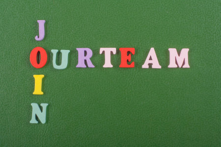 JOIN OUR TEAM word on green background composed from colorful abc alphabet block wooden letters, copy space for ad text. Learning english concept.の写真素材