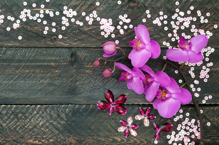 Orchid flower, crystals and sequins on the old wooden background. view from aboveの写真素材
