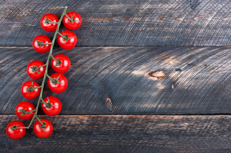 Cherry tomatoes on a wooden table. Vegetables on a rustic wooden background. Top viewの写真素材