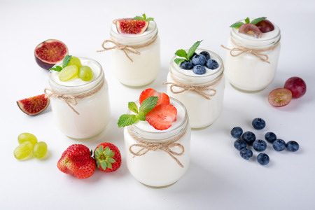 Fresh yogurt with berries in glass jars. Healthy food, dieting and breakfast concept. Dairy productsの写真素材