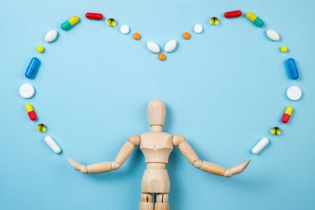 Figure of human and pharmaceutical medicine pills, tablets on blue background. Health care, daily pills, antidepressants, medicine, treatment concept. Copy spaceの写真素材