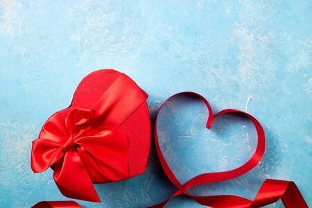 Valentines Day background with red heart and gift box. Heart shape from ribbons. Happy Valentine Dayの写真素材