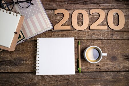 Office desk table with notebooks, coffee cup, american flag. New year 2020 resolutions or goals list. Goal, plan, strategy, politics, international relations, economics, american history conceptの写真素材