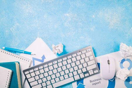 Office desk with business supplies. Workplace with papers, documents, keyboard, notebooks. Business report, office work and deadline concept. Top viewの写真素材
