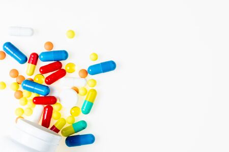 Pill bottle with assorted pharmaceutical medicine pills, tablets, capsules on white background top...