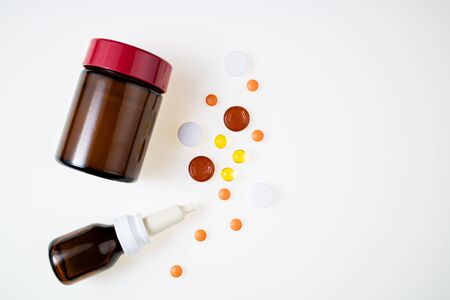 Pharmaceutical medicine pills, tablets, capsules, nasal drops and ointment on white background top view. Medical pharmacy, flu, influenza, therapy concept. Flat lay, copy spaceの写真素材