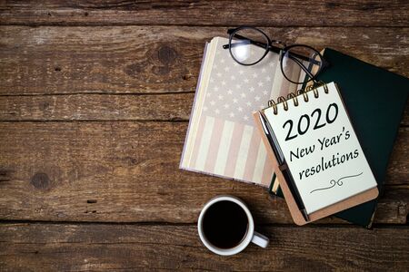 New Years resolutions 2020 on office desk table with coffee cup, american history book, pen, notebook and eyeglasses. Educations, resolutions, goal, plan, strategy, politics concept
の写真素材