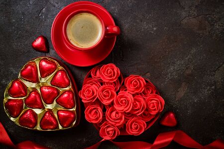 Valentines Day background with red heart, chocolate bonbons and coffee cup. Heart shape from ribbons and flowers rose. Happy Valentine Dayの写真素材