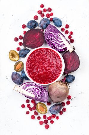Smoothies bowl with purple fruit and vegetables on white background. Healthy eating and diet concept. Top viewの写真素材