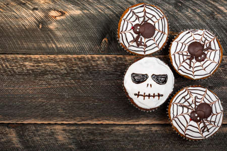 Funny delicious halloween cakes on old dark rustic wooden table. Halloween background with cakes for party. Autumn, halloween, party concept. Copy space, top viewの写真素材