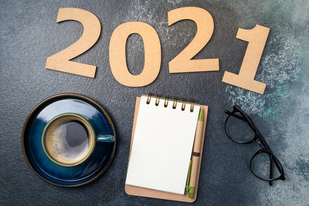 New year 2021 and notebook on desk. 2021 template with open notebook, coffee cup, eyeglasses on blue background. Goals, plan, strategy, resolutions, idea concept. Copy spaceの写真素材