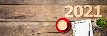 New year resolutions 2021 on desk. 2021 resolutions with notebook, coffee cup, succulent, eyeglasses on wooden background. Goals, plan, strategy, list, idea concept. New Year 2021 template with copy spaceの写真素材