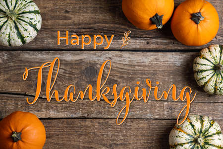 Thanksgiving Greetings. Pumpkins on rustic wooden background. Top view. Happy Thanksgiving text with pumpkins. Top viewの写真素材