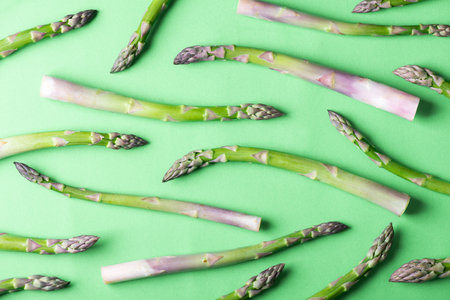Fresh asparagus pattern. Creative background of asparagus on green. Healthy food concept. Top view, flat layの写真素材