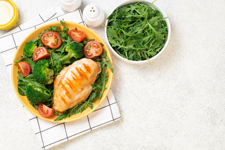 Cooked chicken fillet with fresh vegetable salad. Chicken breast and green vegetables, broccoli on table. Healthy food, keto diet concept. Healthy lunch menuの写真素材