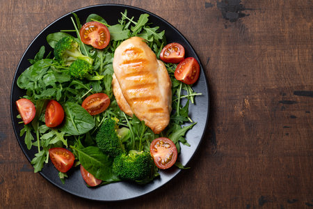 Cooked chicken fillet with fresh vegetable salad. Chicken breast and green vegetables, broccoli on table. Healthy food, keto diet concept. Healthy lunch menuの写真素材