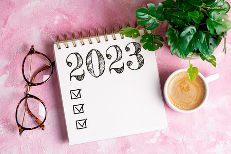 New year resolutions 2023 on desk. 2023 resolutions list with notebook, coffee cup on table. Goals, resolutions, plan, action, checklist concept. New Year 2023 template, copy spaceの写真素材