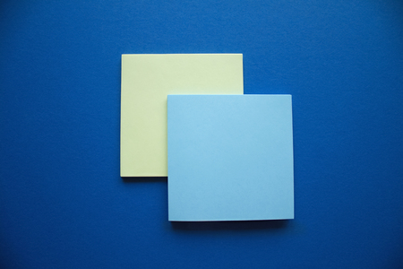 Two blue and yellow square stiker blocks arranged on the dark blue background.の写真素材