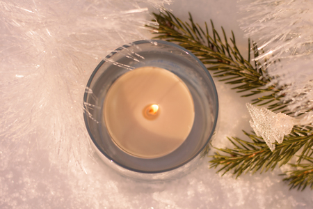 Beautiful white shining decorations of christmas tree, with candle in the glass, lights, snowflacks and shining ribbon.の写真素材