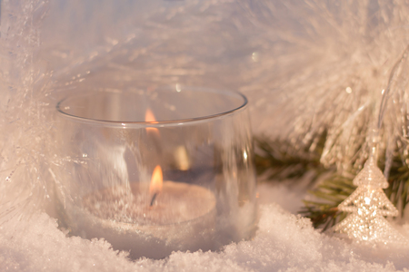 Beautiful white shining decorations of christmas tree, with candle in the glass, lights, snowflacks and shining ribbon.の写真素材