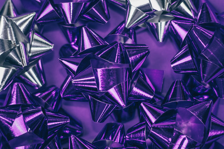 Christmas ornament of several violet and silver shiny decorations on violet background.の写真素材