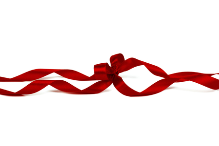 Beautiful decorative shiny red silk ribbon with a bow on isolated white background. Cut out.の写真素材