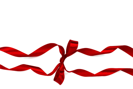 Beautiful decorative shiny red silk ribbon with a bow on isolated white background. Cut out.の写真素材
