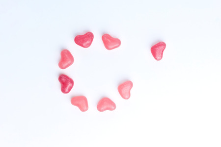 Concept of a lonely heart made of heart shaped pink jelly sweets on isolated white background. Valentines Day. Top view. Copy space.の写真素材